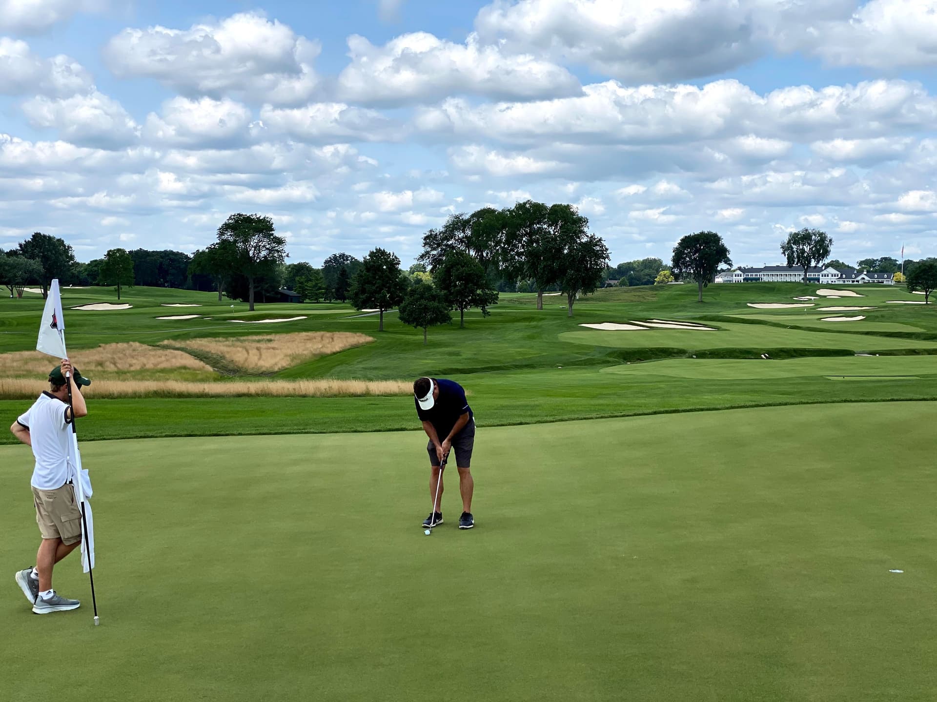 Golfer putting with caddie